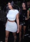 Kim Kardashian flaunts her toned tummy in midriff-baring white ensemble as she parties with friends in Miami